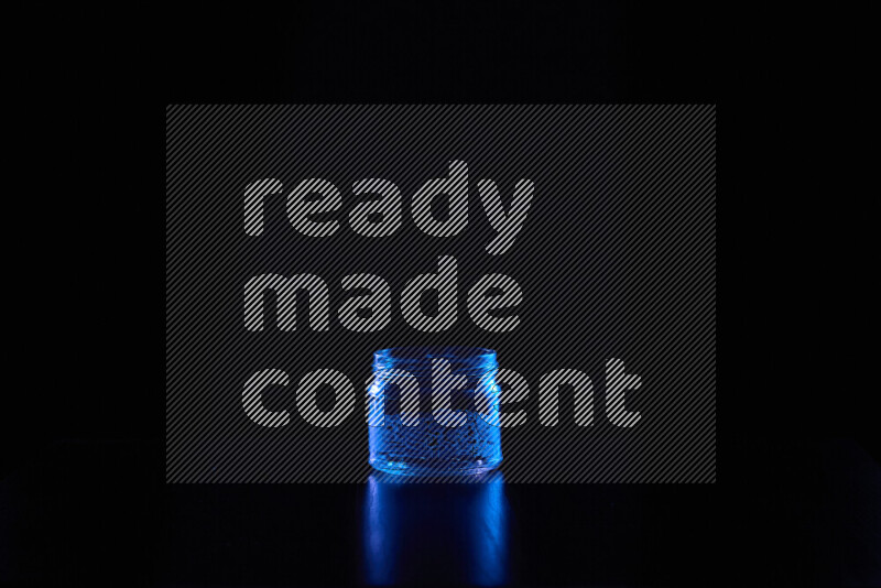 Glassware with rim light in blue against black background