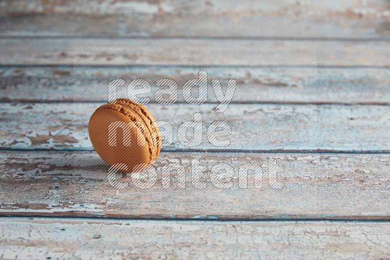 45º Shot of Brown Maple Taffy macaron on light blue wooden background