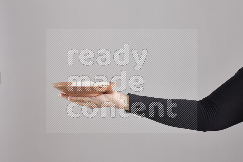 A woman in black abaya holding different pottery essentials in different positions