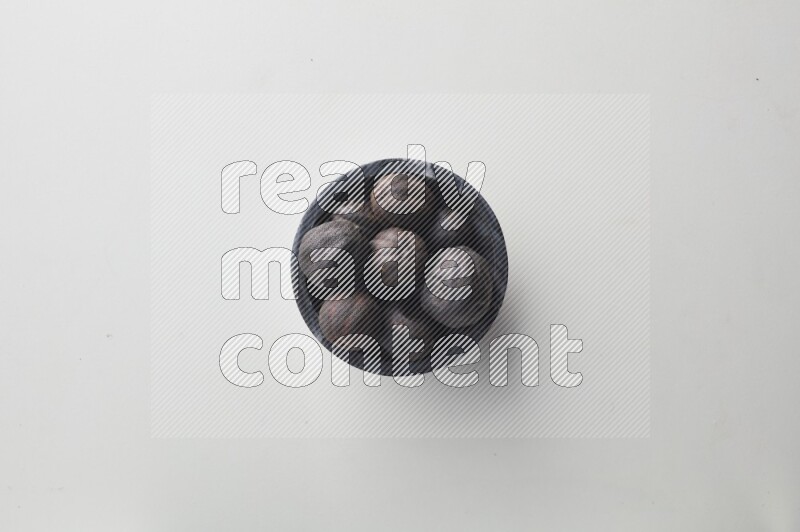Top-view shot of dried lime (loomi) in a container on white background