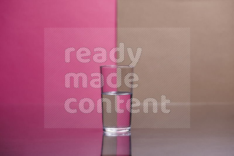 The image features a clear glassware filled with water, set against pink and beige background