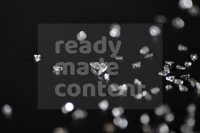 قطع زجاجية فضية لامعة متناثرة على خلفية سوداء