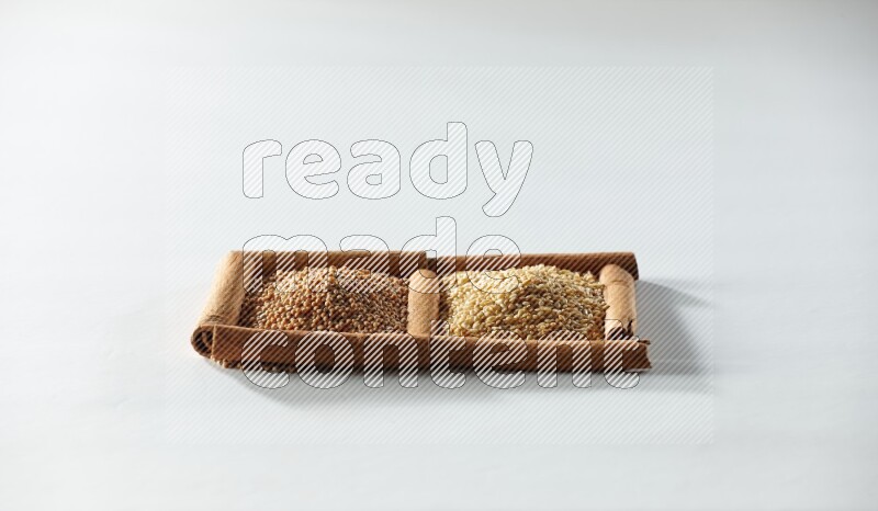 2 squares of cinnamon sticks full of mustard seeds and sesame on white flooring