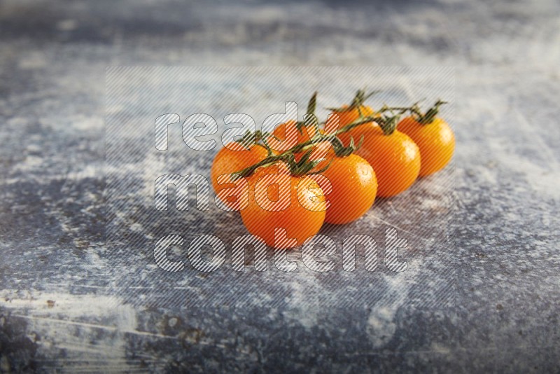 Orange cherry tomato vein on a textured rusty blue background 45 degree