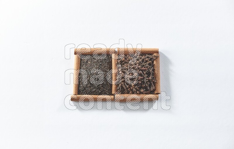 2 squares of cinnamon sticks full of black tea and cloves on white flooring