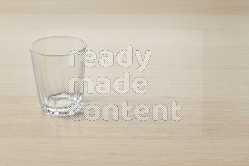 An empty glass cup on light wooden background