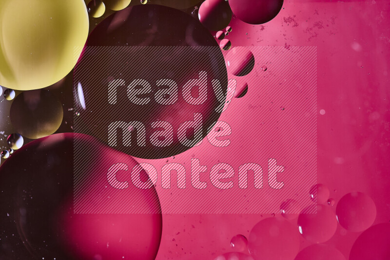 لقطات مقربة لفقاعات من الزيت على سطح الماء باللون الأصفر والوردي