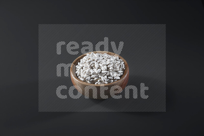 Snacks in a wooden bowl on grey background