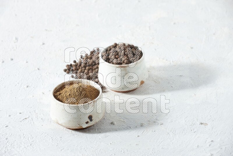 2 beige bowls, one full of powder and the other full of whole balls with balls and powder spreaded on a textured white flooring