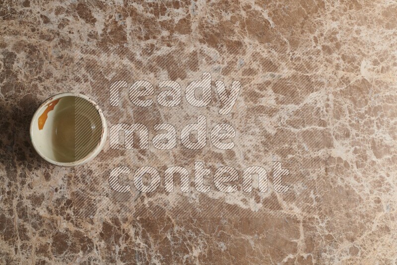 A white pottery bowl on beige marble background