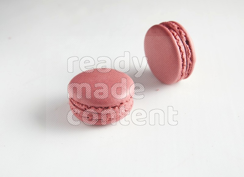 45º Shot of two Pink Raspberry macarons on white background