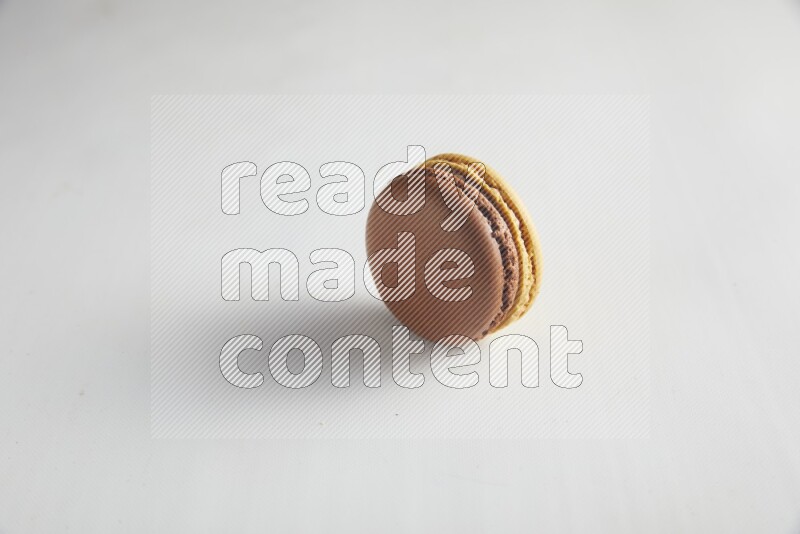 45º Shot of Yellow and Brown Chai Latte macaron on white background