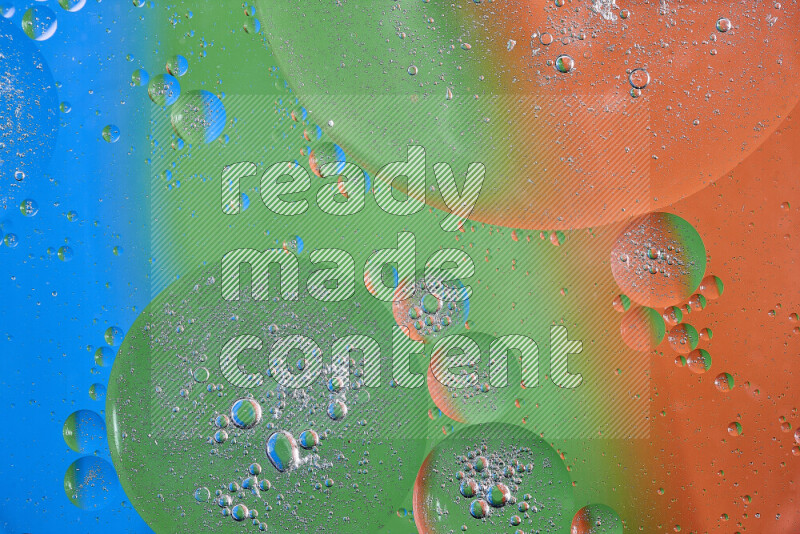 لقطات مقربة لفقاعات من الزيت على سطح الماء باللون البرتقالي والأخضر والأزرق