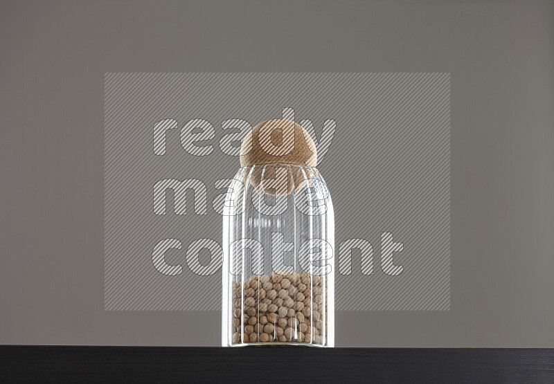 Chickpeas in a glass jar on black background