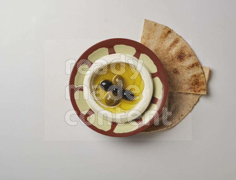 Lebnah garnished with olives in a traditional plate on a white background