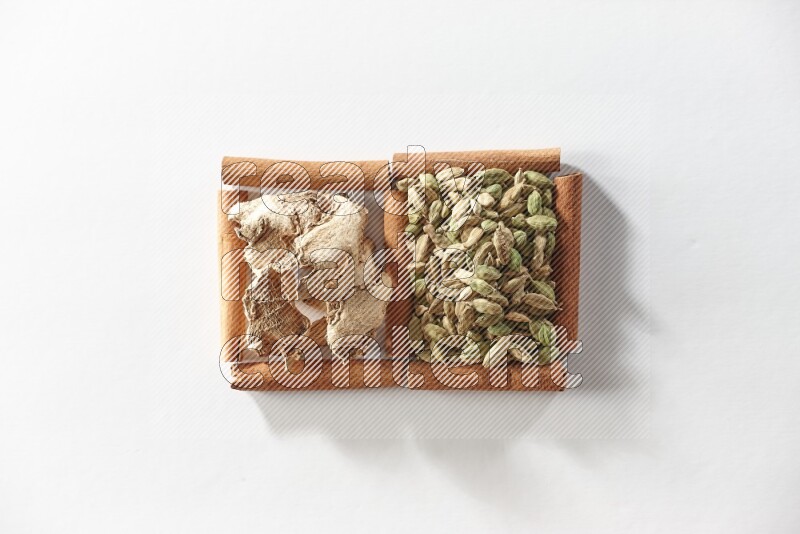 2 squares of cinnamon sticks full of cardamom and dried ginger on white flooring