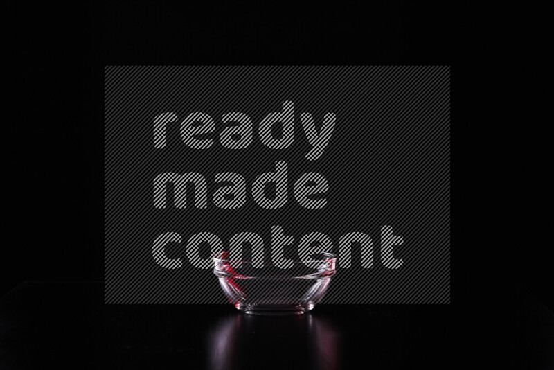 Glassware with rim light in red and white against black background