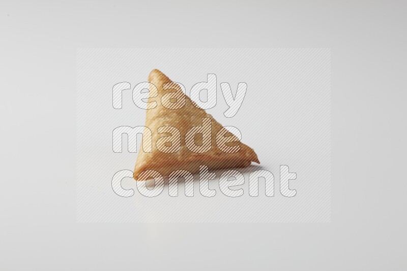 One fried sambosa on a white background