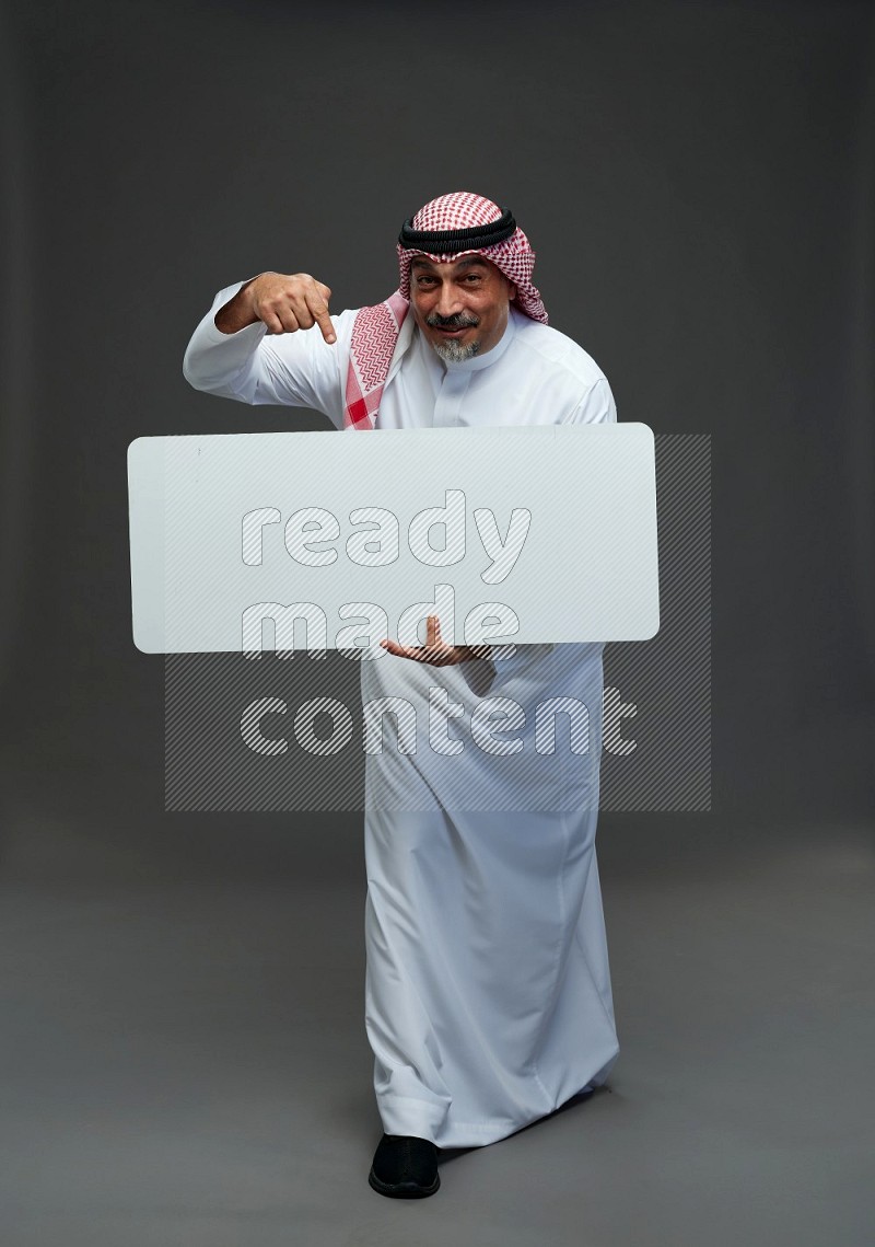 Saudi man with shomag Standing holding social media sing on gray background