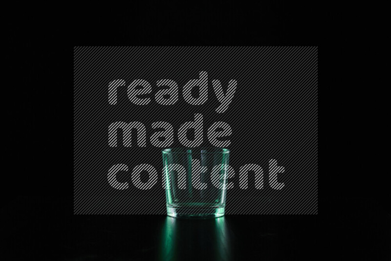 Glassware with rim light in green against black background