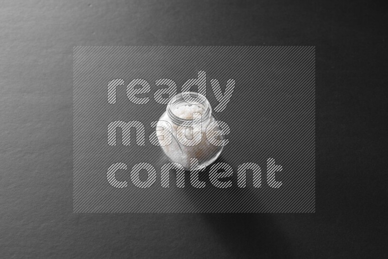 ملح في وعاء زجاجي علي خلفية سوداء