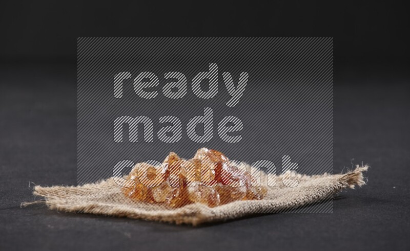 Gum arabic on a burlap piece on black flooring