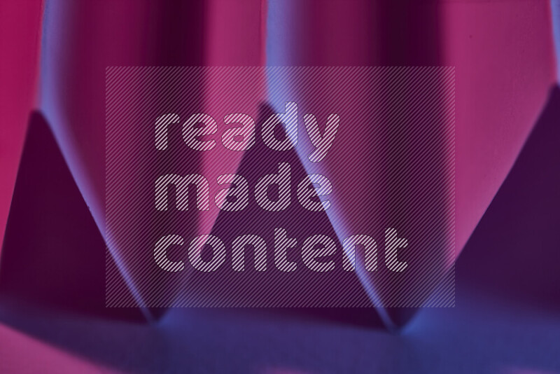 A close-up abstract image showing sharp geometric paper folds in purple gradients