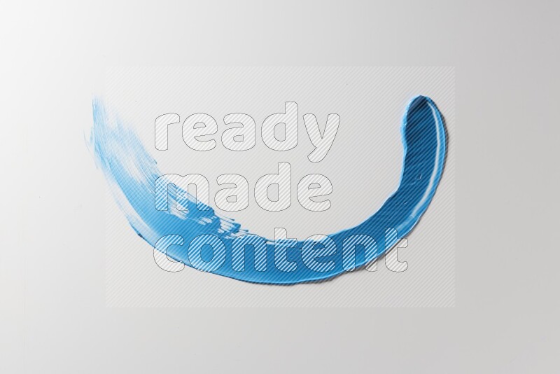 A blue single curved painting knife stroke on a white background