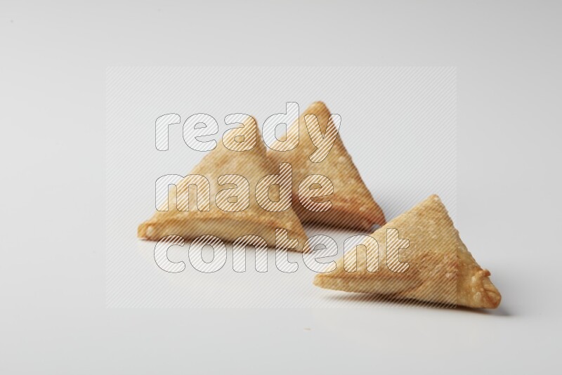 Three fried sambosas on a white background
