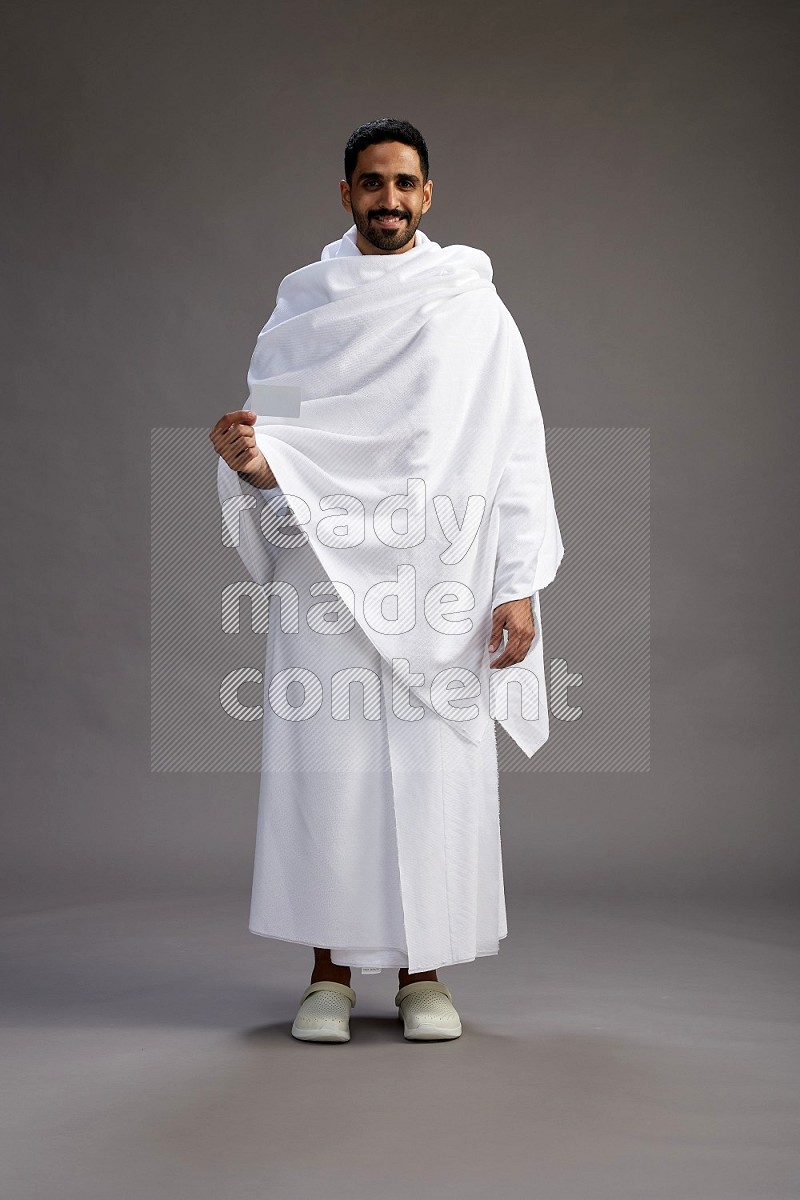 A man wearing Ehram Standing holding ATM card on gray background