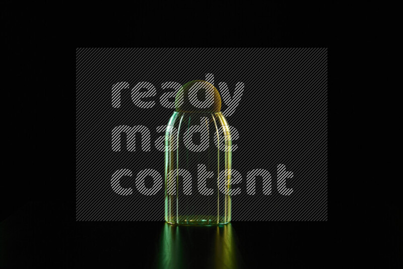 Glassware with rim light in green and yellow against black background