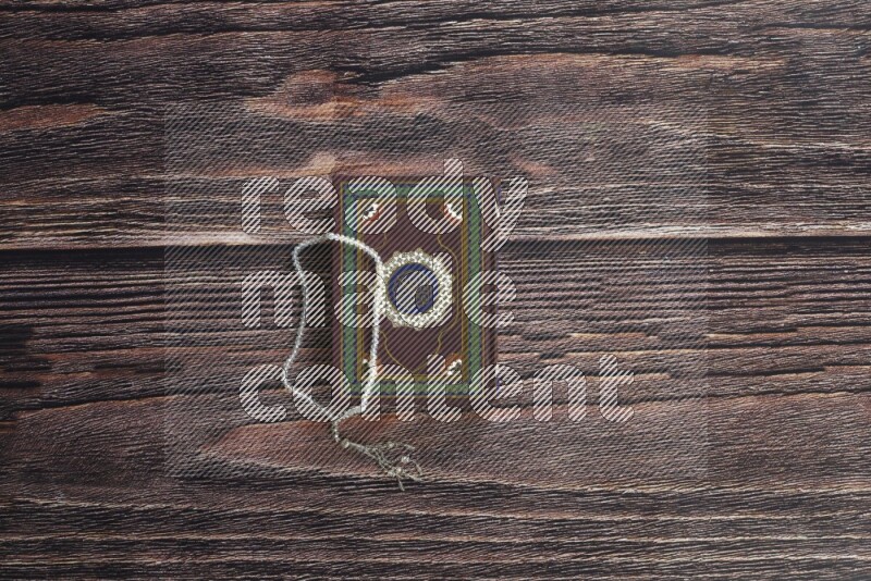 Quran with a prayer beads on wooden background