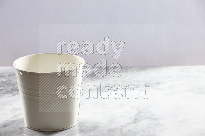 An empty white plant pot on grey marble background