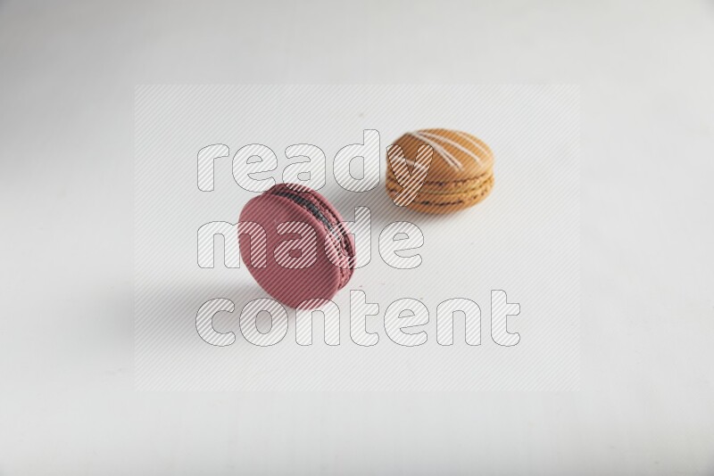 45º Shot of of two assorted Brown Irish Cream, and Red Cherry macarons on white background