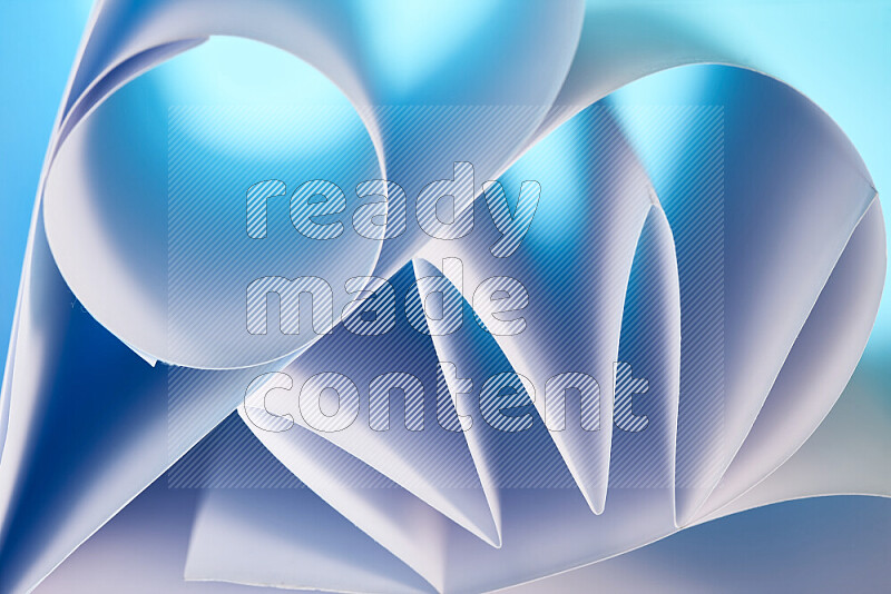 عرض فني لطيات الورق تخلق مزيج من الأشكال الهندسية، مضاءة بإضاءة ناعمة بدرجات اللون الأزرق والأبيض