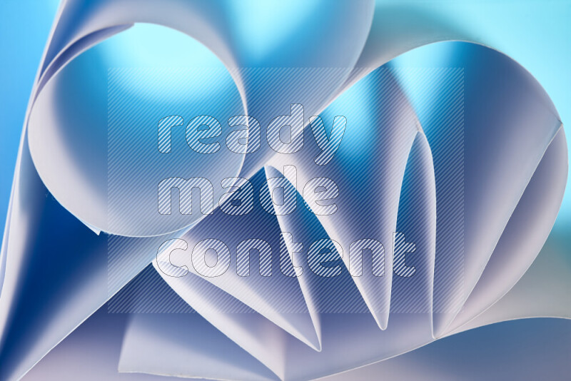 عرض فني لطيات الورق تخلق مزيج من الأشكال الهندسية، مضاءة بإضاءة ناعمة بدرجات اللون الأزرق والأبيض