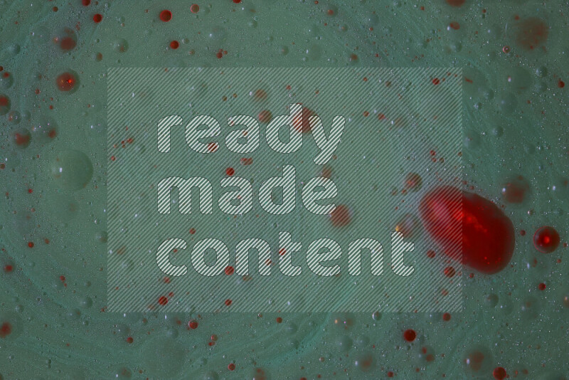 تلتقط الصورة تناثرا للطلاء الأحمر علي خلفية خضراء