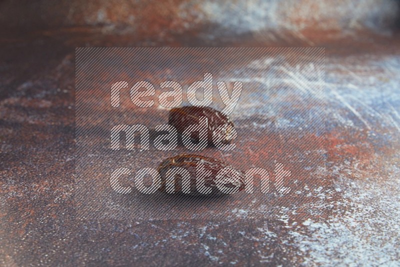 two madjoul dates on a rustic reddish background