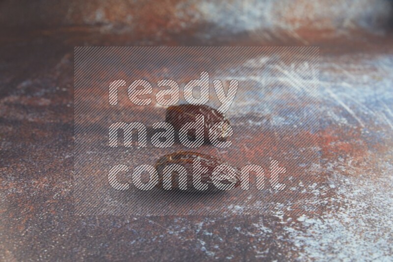 two madjoul dates on a rustic reddish background