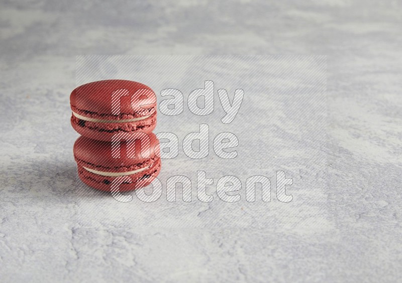 45º Shot of two Red Velvet macarons  on white  marble background