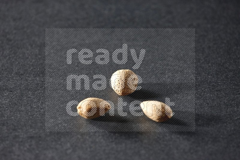 3 almonds on a black background in different angles