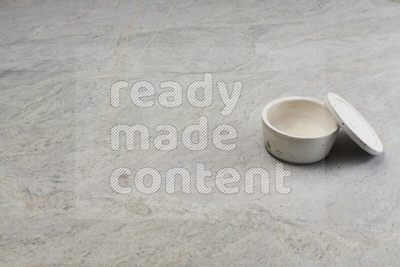 A white pottery bowl on grey marble background