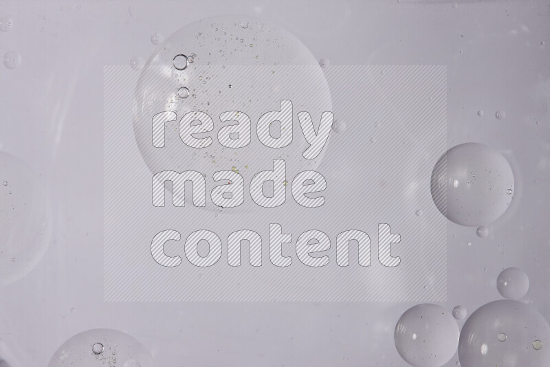 قطرات من الزيت على سطح الماء على خلفية بيضاء