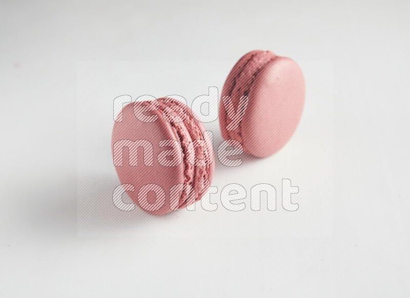 45º Shot of two Pink Raspberry macarons on white background
