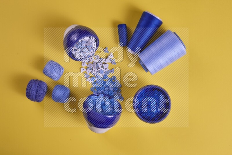 A blue collection of sewing and tailoring tools arranged on a yellow background