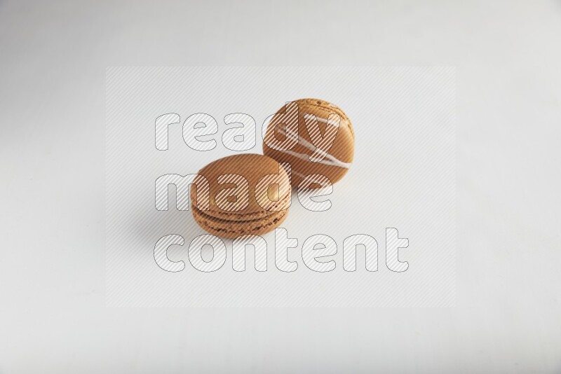 45º Shot of of two assorted Brown Irish Cream, and Brown Coffee macarons  on white background