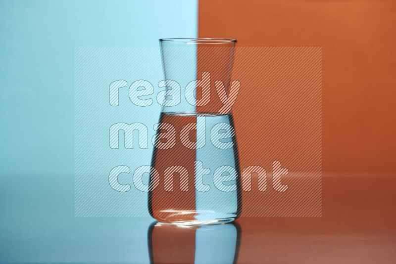 The image features a clear glassware filled with water, set against light blue and dark orange background