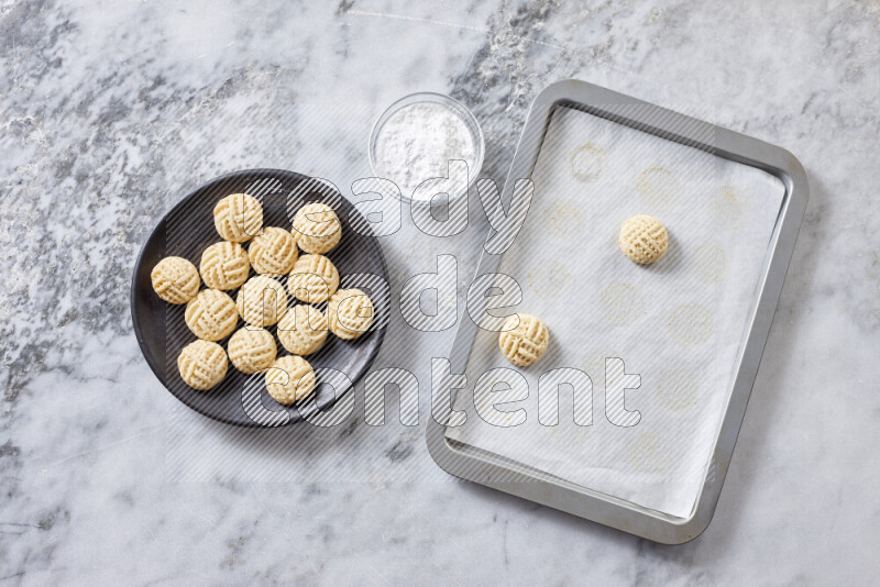 Kahk step by step with its ingredients ghee, sugar, flour, sesame, yeast, water and kahk flavor on grey marble background