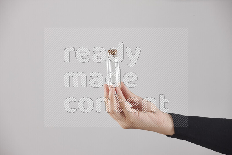 A woman in black abaya holding different glassware in different positions
