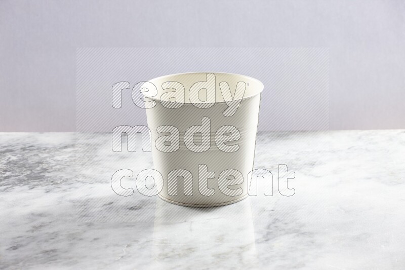 An empty white plant pot on grey marble background